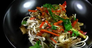 Siyah bir arka planda sebze ve et ile Asya noodle.