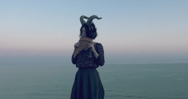 海の背景に山のヤギの角を持つ女の子 — ストック動画