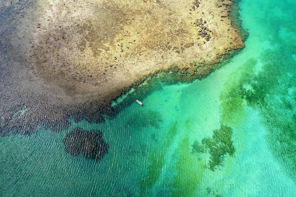 Aerial view of Sao Miguel dos Milagres Beach, Alagoas, Brazil: unique experience of swimming with fishs in natural pools. Fantastic vacation travel. Great beach scene. Beautiful landscape. Candles, sailboats, rafts, boats in the harbor! Great scene!