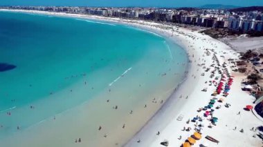 Rio de Janeiro Tropikal Plajı. Cabo Frio Şehri, Rio de Janeiro. Tatil seyahati. Seyahat güzergahı. Sakin ol. Sakin ol. Boş zaman. Plajda dinlenen insanlar. Turkuaz Suyun Hava Görüntüsü. Coastal City. Rio