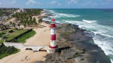 Sahildeki deniz feneri, Salvador, Bahia, Brezilya. Sahil feneri. Sahildeki deniz fenerinin kıyısında. Itapua deniz feneri sahnesi. Farol de Itapua sahnesi. Itapua deniz feneri, Salvador, Bahia. Farol de Itapua sahilde, Salvador, Bahia.