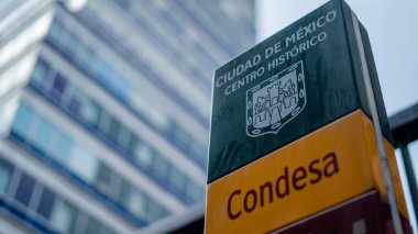 Arka tarafında Latin Amerika Kulesi olan bir Condesa Mahallesi tabelası.