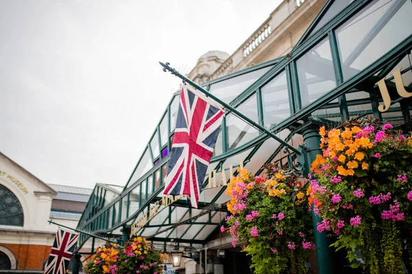 O sinal Jubilee Market Hall entre duas bandeiras britânicas — Fotografia de Stock