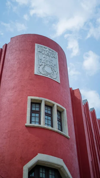 Piedra Antiguo arte azteca en la pared curva de un edificio rojo — Foto de Stock