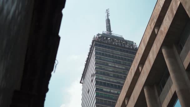 4k Utsikt över det latinamerikanska tornet bakom två byggnader — Stockvideo
