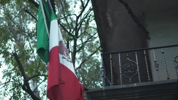4k Mexická vlajka vedle kovového balkónu a stromu — Stock video