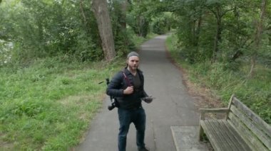 Bir İHA Ağaçların Arasında Hareket Ederken Bir Yol Üzerinde Yürüyen Adam 'ın 4k Hava Çekimi