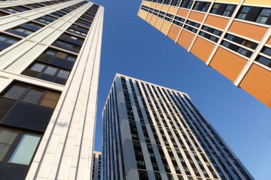 Modern yerleşim binalarının inşası, mavi gökyüzüne karşı soyut gökdelenler