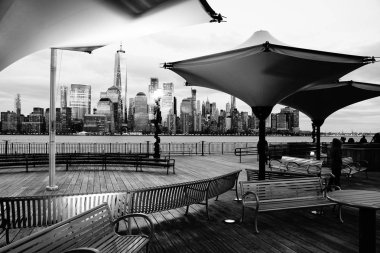 Jersey City, Nj / Amerika Birleşik Devletleri - 01 01 2019: New York City üzerinden J Owen Grundy Park, New Jersey nefes kesen manzarası. Şemsiye ve banklar ile nehir kenarında. Siyah ve beyaz. B&W.