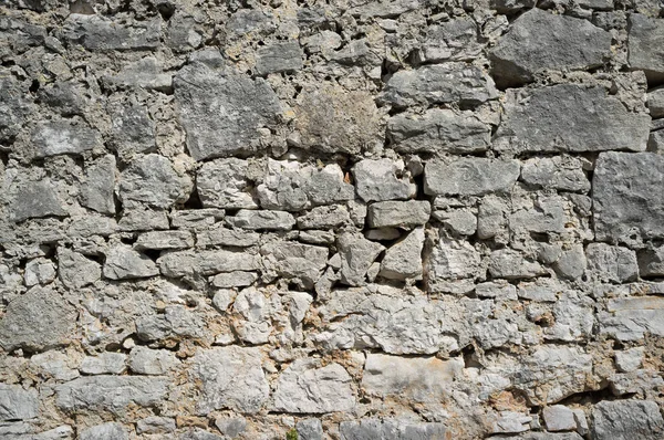 Старая Грэмми и вымотанная каменная стена — стоковое фото