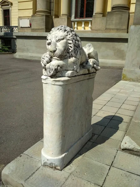 statue of a stone lion sleeping on a pedestal