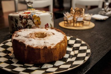 koyu ahşap arka plan üzerine toz şekeri ile sade kek. seçici odak