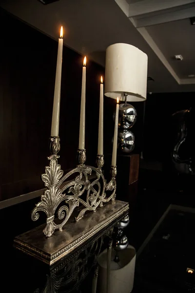 candles and lamp on a table in a living room. decoration concept