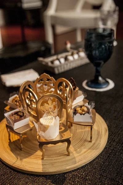 elegant party candy in small decorative golden chairs. party decoration concept.