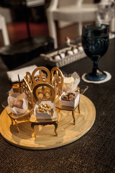 elegant party candy in small decorative golden chairs. party decoration concept.