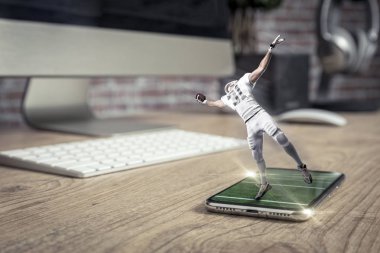 Oynama ve iyi bir tam ekran telefon ahşap bir masaya geliyor beyaz üniforma ile futbolcu. Talep kavramı üzerinde bir futbol maçı izliyor. kopya alanı.