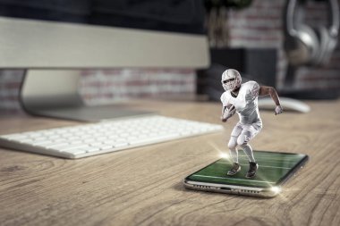 Oynama ve iyi bir tam ekran telefon ahşap bir masaya geliyor beyaz üniforma ile futbolcu. Talep kavramı üzerinde bir futbol maçı izliyor. kopya alanı.