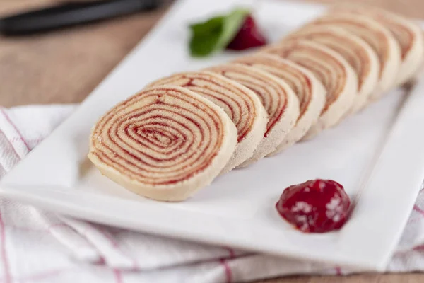 Bolo de rolo (swiss roll, roll cake) typical Brazilian dessert, from the state of Pernambuco. Sliced cake roll filled with Guava paste.