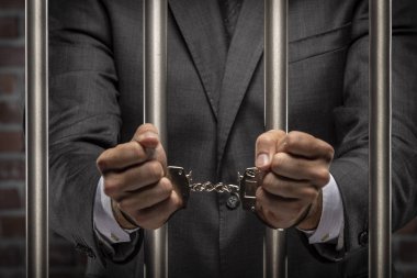 Brezilyalı adam para bir kelepçe ile faturalar bir hapiste tutan. yolsuzluk, yozlaşmış siyasetçiler, yasadışı işletmeler kavramı. tuğla arka plan.