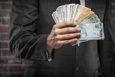 Brezilyalı adam para bir kelepçe ile faturalar bir hapiste tutan. yolsuzluk, yozlaşmış siyasetçiler, yasadışı işletmeler kavramı. tuğla arka plan.