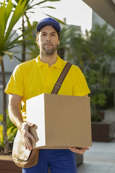Carteiro brasileiro entregando um pacote . — Fotografia de Stock