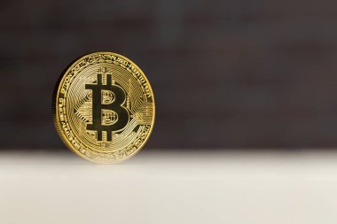 beyaz bir masada duran fiziksel bitcoin