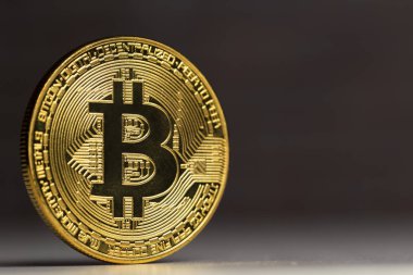 beyaz bir masada duran fiziksel bitcoin