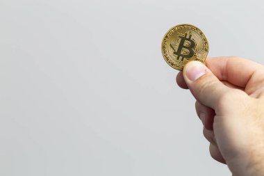 fiziksel bir bitcoin tutan adam el