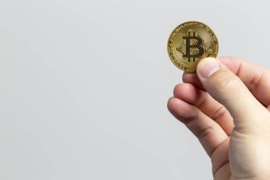 fiziksel bir bitcoin tutan adam el