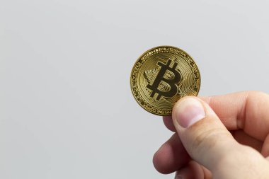 fiziksel bir bitcoin tutan adam el