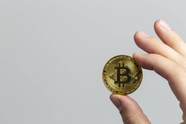 fiziksel bir bitcoin tutan adam el
