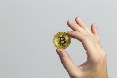 fiziksel bir bitcoin tutan adam el