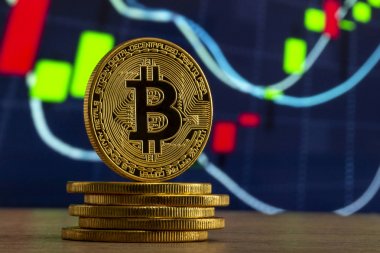 fiziksel bitcoin Mavi grafik önünde ahşap bir masada duran
