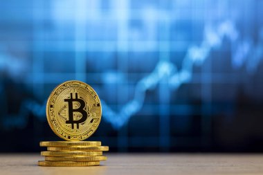 fiziksel bitcoin Mavi grafik önünde ahşap bir masada duran