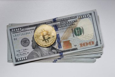 Dolar banknotlarının üstüne Bitcoin sikkesi.