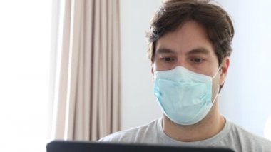 Yatakta çalışan bir adam, yüzü olan, hasta olduğu için ev işi yapan bir adam. 4k içinde.