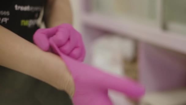 Preparación para el trabajo en un salón de belleza, ponerse guantes — Vídeos de Stock