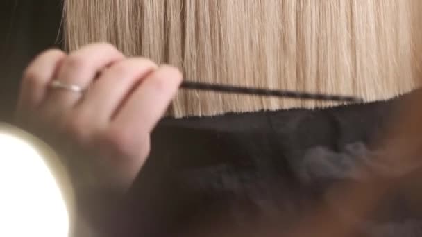 Der Friseur gleicht die goldenen Haarspitzen aus — Stockvideo