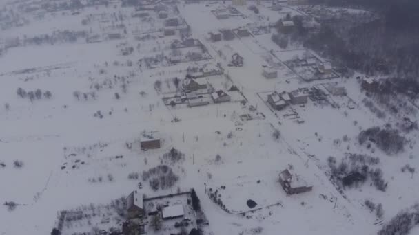 Voo na aldeia de inverno com neve ao amanhecer no dron — Vídeo de Stock