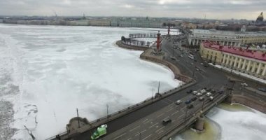 Havadan görünüm. Kışın bulutlu soğuk havalarda Neva nehri boyunca uçmak. Petersburg nehri üzerindeki köprü. Donmuş nehir üzerinde uçuş kuşların yüksekliği.