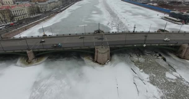 공중 보기. 겨울에 네바 강을 따라 비행하는 추운 날씨. 피터스버그 강을 가로지르는 다리. 얼어붙은 강을 날아가는 새들의 높이. — 비디오