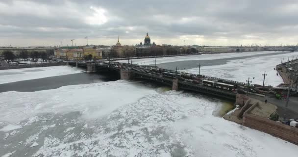 Widok z lotu ptaka. Latanie wzdłuż rzeki Neva w zimie pochmurny zimno. Most nad rzeką Petersburg. Wysokość lotu ptaków nad zamarzniętym rzeką. — Wideo stockowe