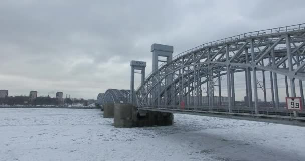 Luchtfoto. Vliegen langs de rivier de Neva in de winter overgegoten koud weer. Brug over de rivier de Petersburg. De hoogte van de vogelvlucht boven de bevroren rivier. — Stockvideo