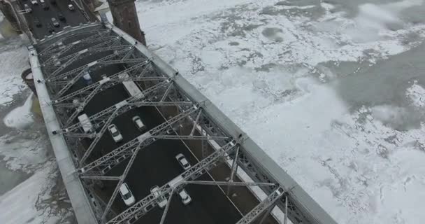 Luchtfoto. Vliegen langs de rivier de Neva in de winter overgegoten koud weer. Brug over de rivier de Petersburg. De hoogte van de vogelvlucht boven de bevroren rivier. — Stockvideo