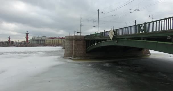 Widok z lotu ptaka. Latanie wzdłuż rzeki Neva w zimie pochmurny zimno. Most nad rzeką Petersburg. Wysokość lotu ptaków nad zamarzniętym rzeką. — Wideo stockowe