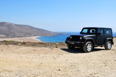 Patikadan bir ayakta Siyah araba ile görünümünü bir arka planda bir tepenin tarafından deniz, Prasonisi, Rodos, Yunanistan
