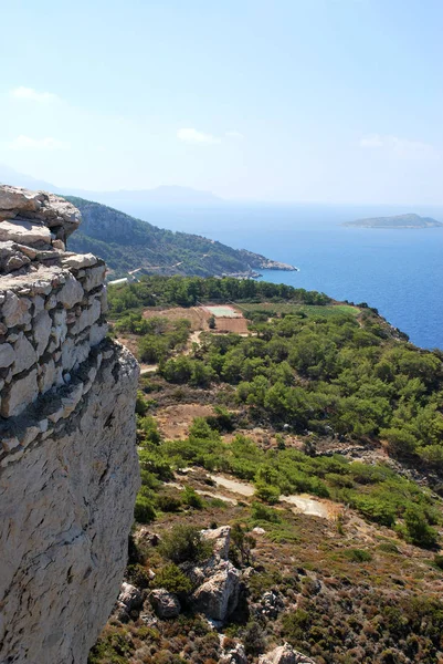 从希腊罗得岛克里尼尼亚村克里尼尼亚城堡遗址的石墙可以看到附近岛屿的景色 — 图库照片