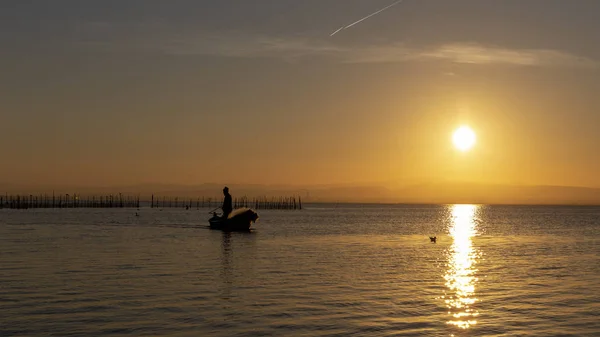 Man fishing in a boat at sunset in Albufera of Valencia. — Stock Photo, Image