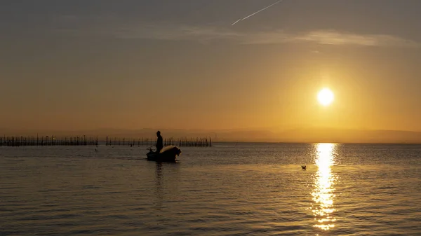 Людина рибалка в човні на заході сонця в Albufera Валенсії. — стокове фото