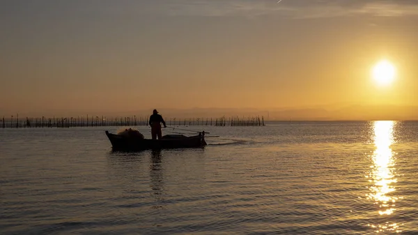 Hombre pescando en un barco al atardecer en Albufera de Valencia . —  Fotos de Stock